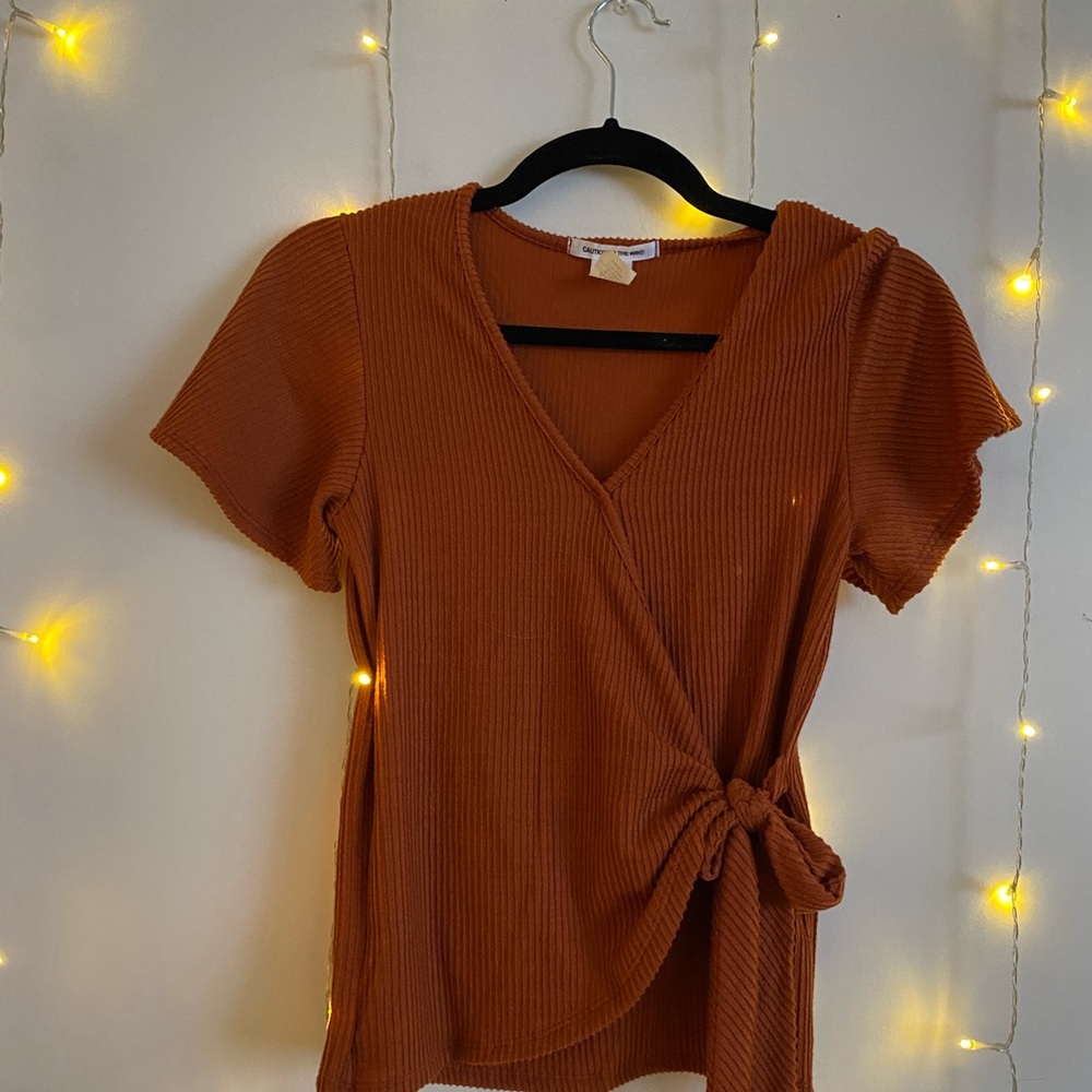 Orange v cut short sleeve shirt with tie in front.